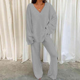 a woman wearing a grey sweater and pants