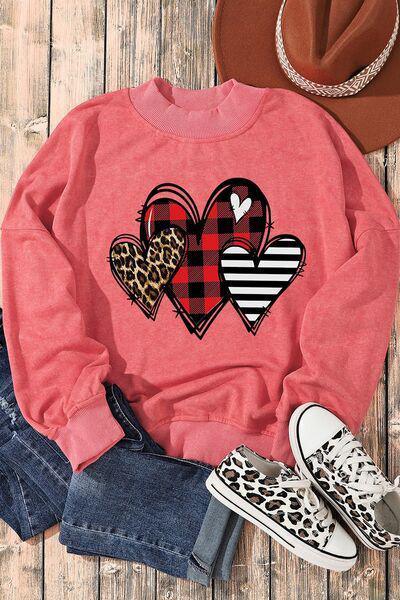 a pink sweater with hearts and leopard print on it