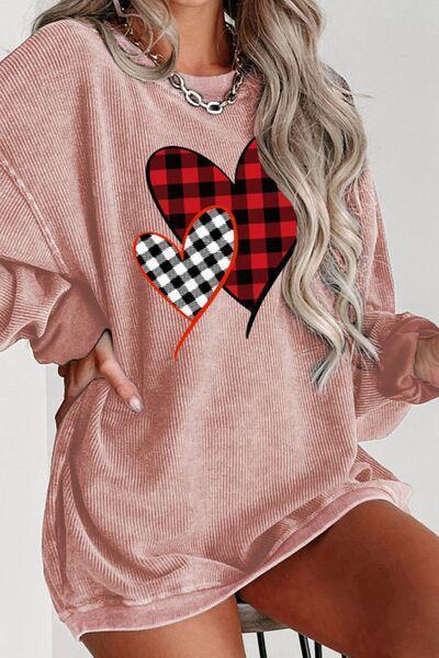 a woman wearing a pink sweater with a heart on it