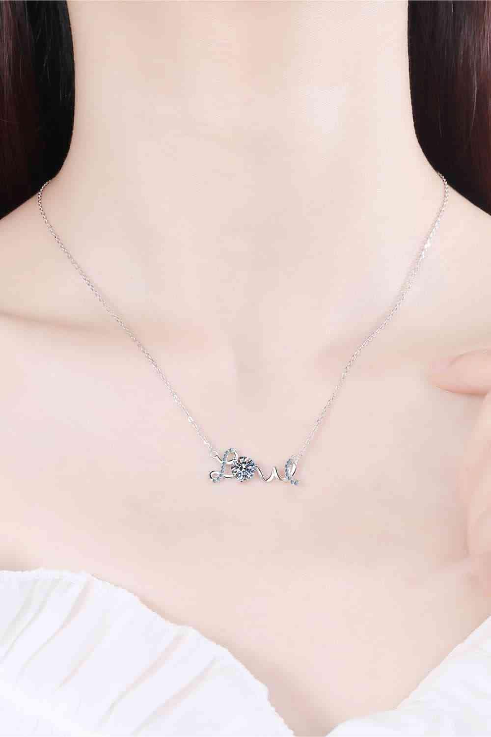 a woman wearing a necklace with the word love on it