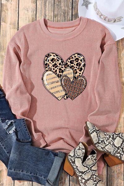 a pink sweater with leopard hearts on it