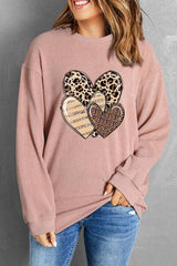 a woman wearing a leopard heart sweater