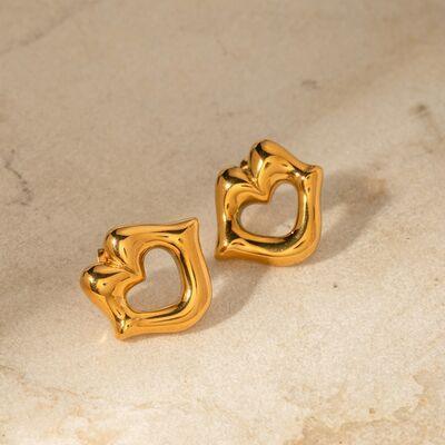 a pair of gold heart shaped earrings on a marble surface