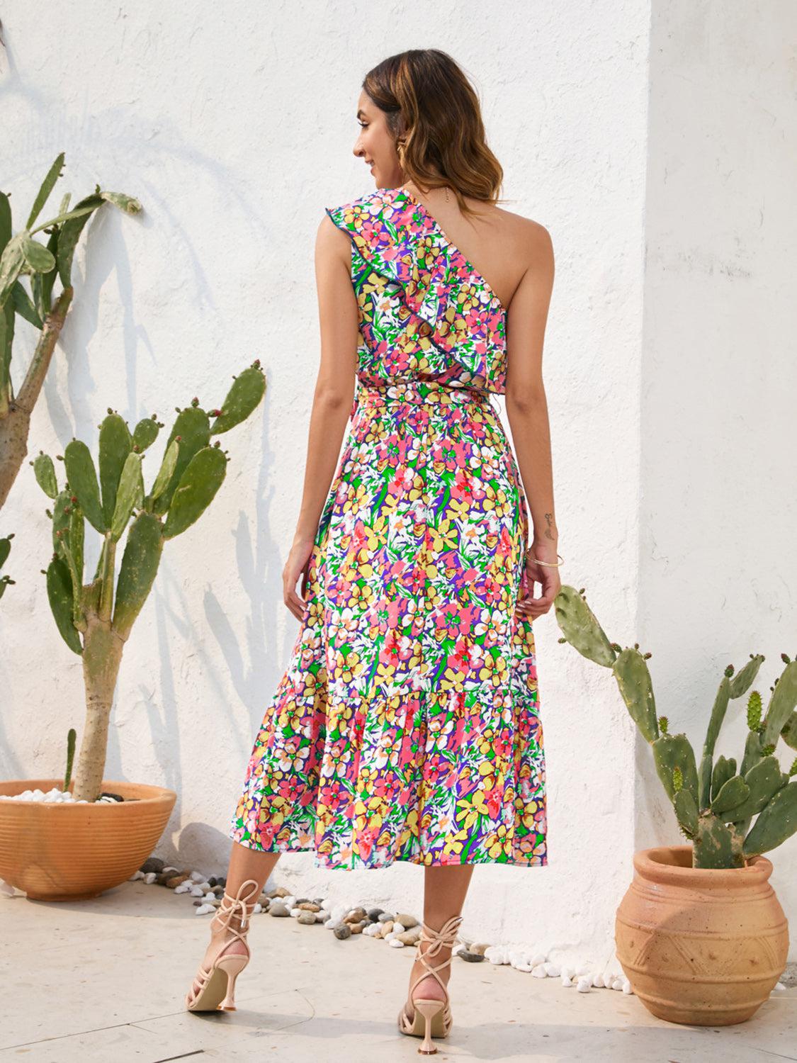 a woman in a colorful dress standing in front of a cactus