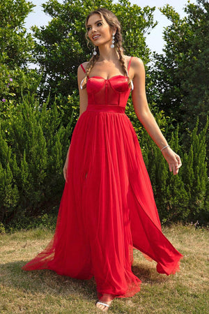 a woman in a red dress standing in the grass