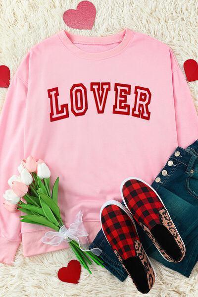 a pink sweater with the word lover written on it