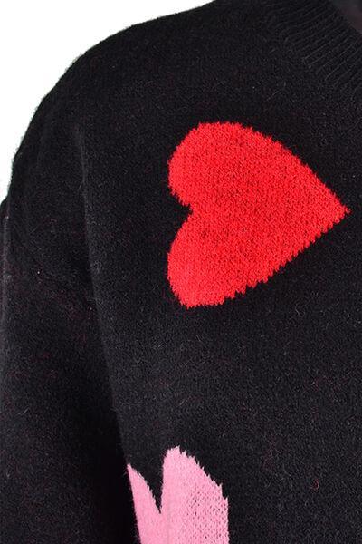 a black sweater with a red heart on it