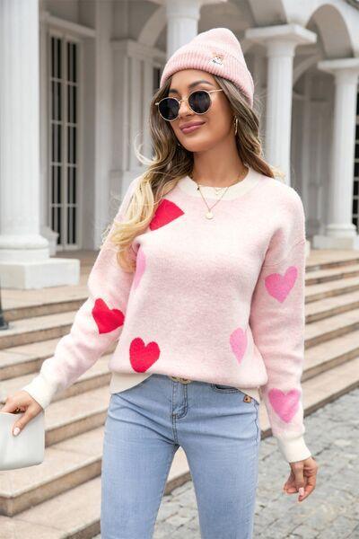 a woman wearing a pink sweater with hearts on it