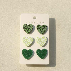 a package of four green heart shaped earrings
