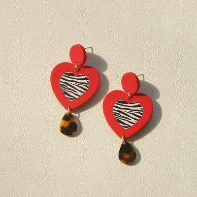 a pair of earrings with a heart and a zebra print