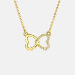 a gold necklace with a heart and a diamond