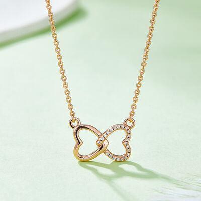 a gold necklace with two hearts on it
