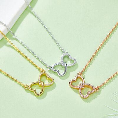 three heart shaped necklaces sitting on top of a table