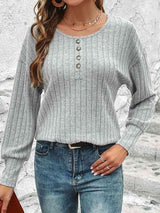 a woman wearing a gray sweater and jeans