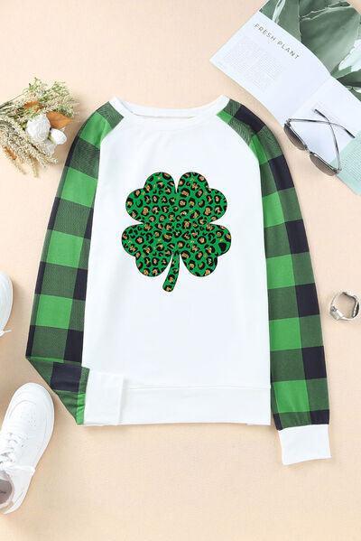 a green and white sweater with a shamrock on it