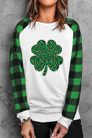 a woman wearing a green and white shirt with a shamrock on it