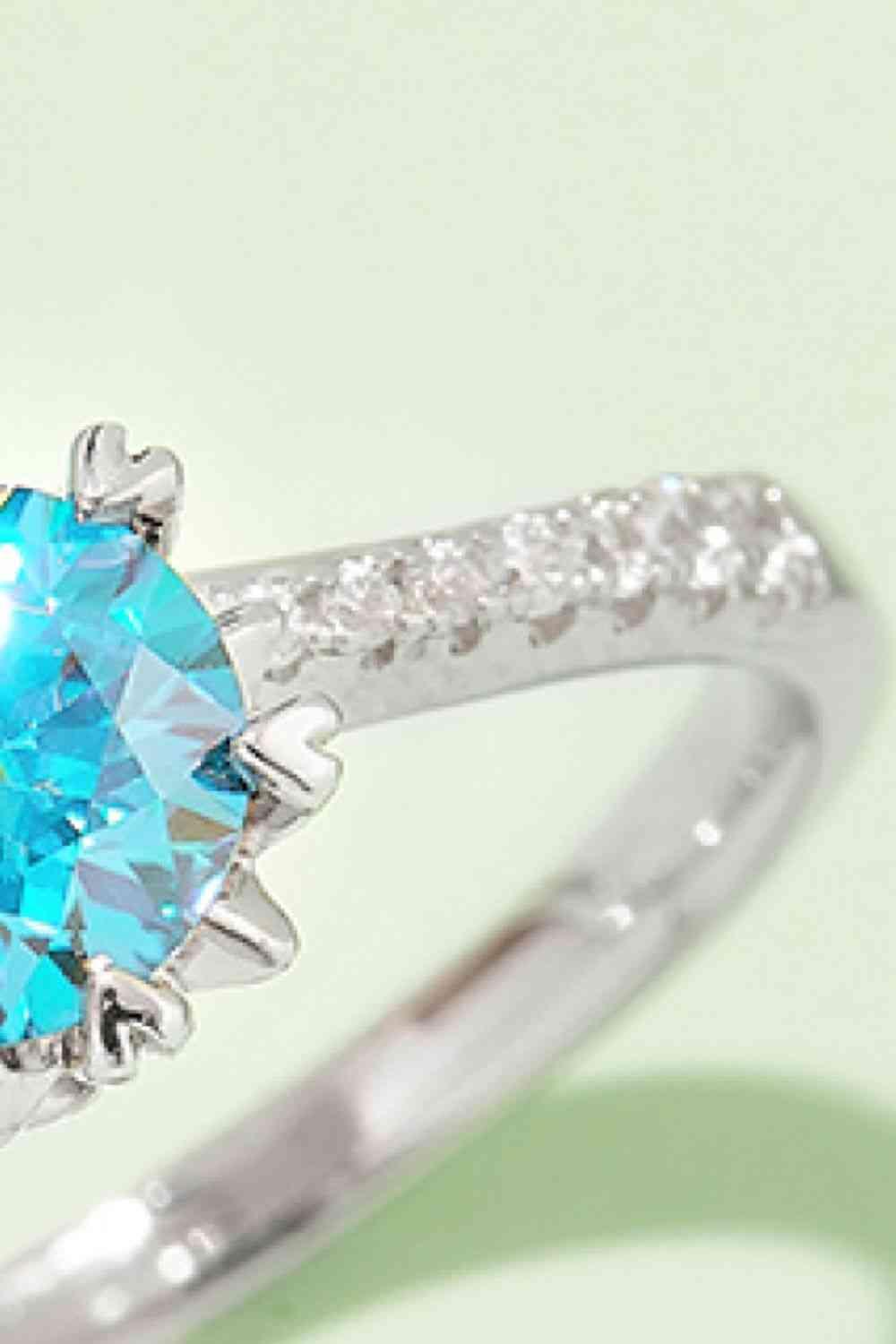 a close up of a ring with a blue stone