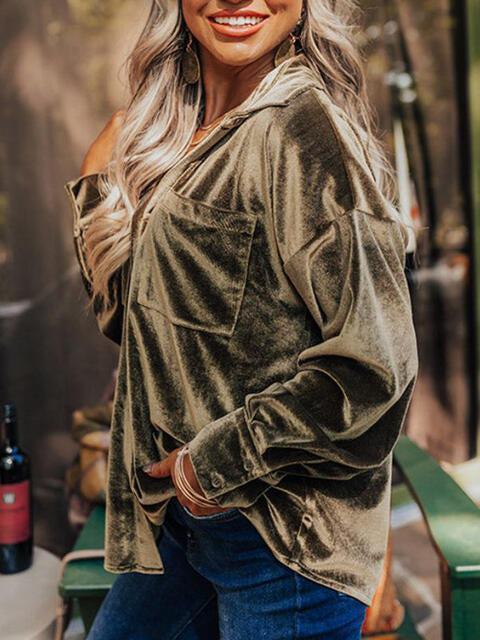 a woman standing in front of a table with a bottle of wine