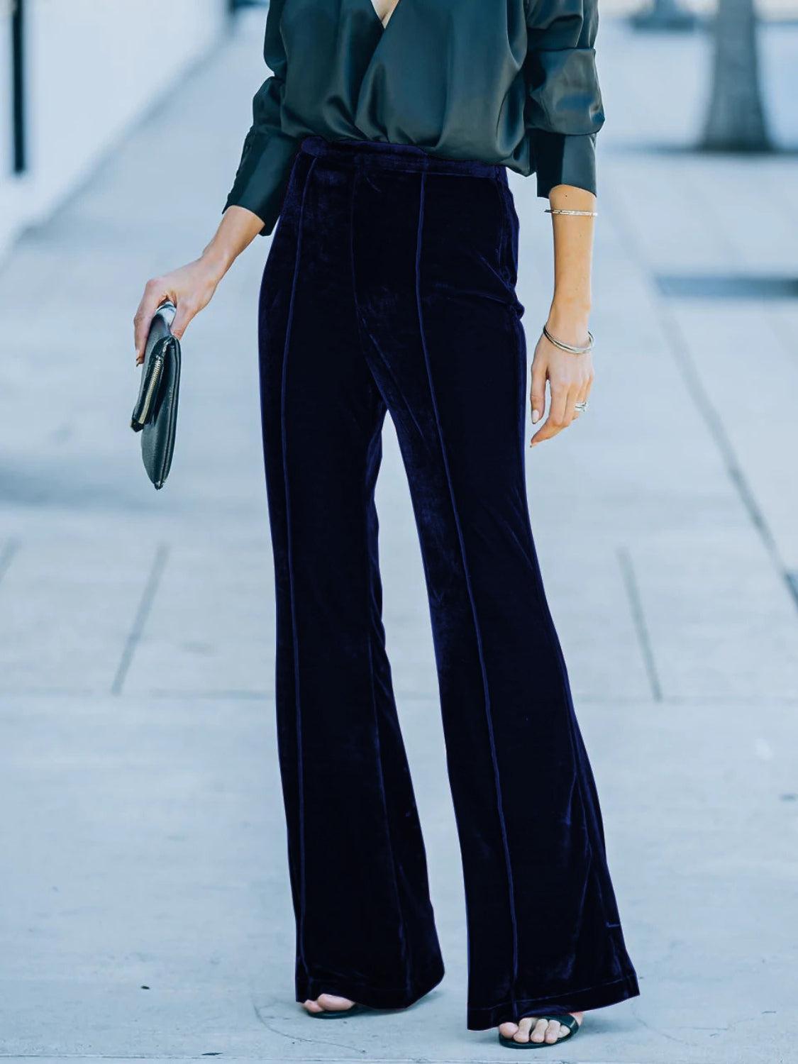 a woman wearing a green blouse and black pants