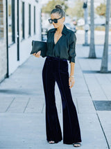 a woman in a black shirt and velvet pants