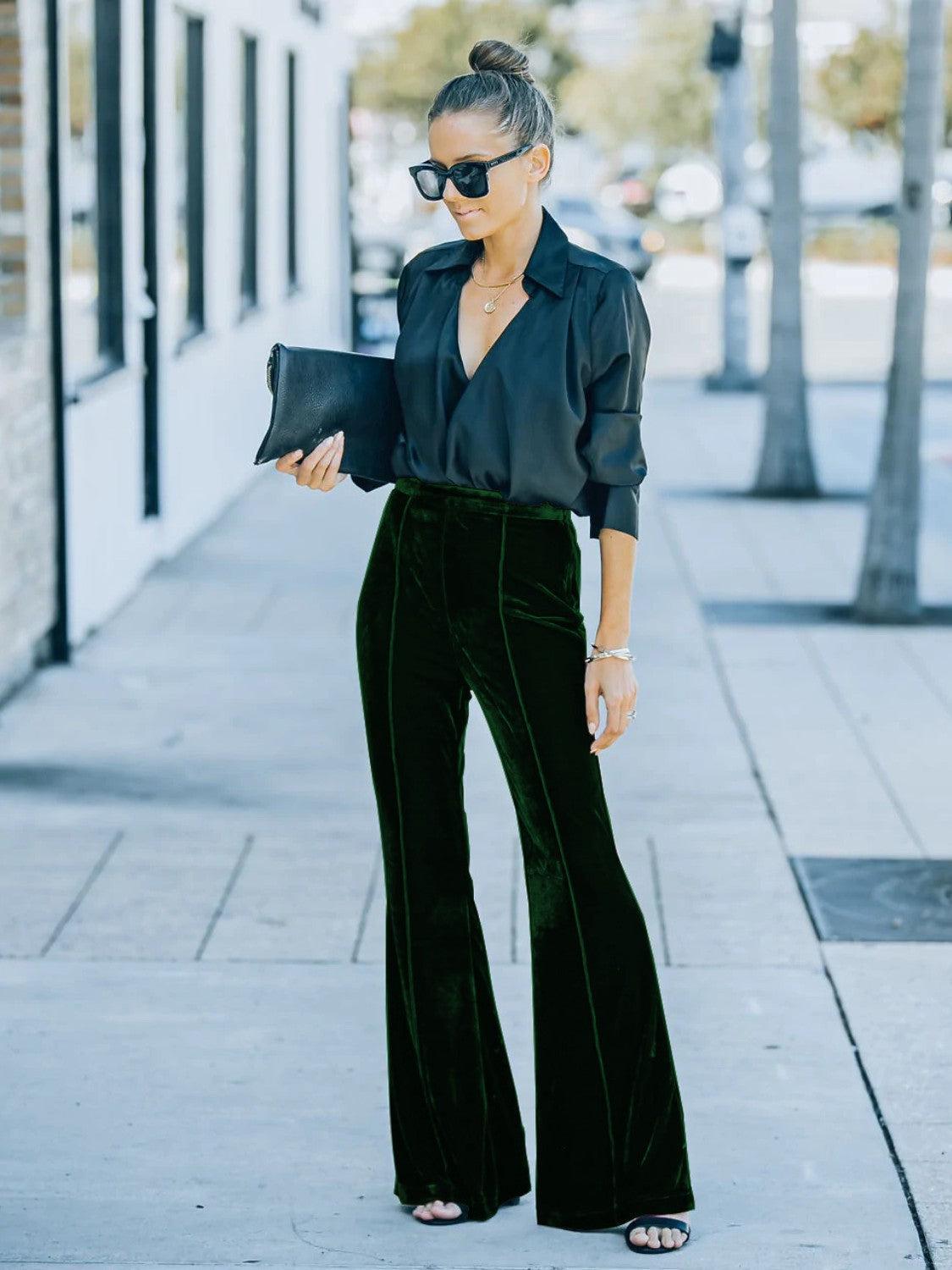 a woman wearing a black shirt and green pants