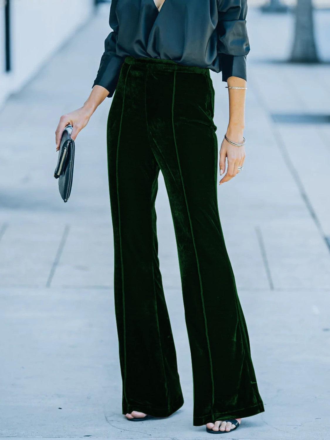 a woman in a black shirt and green pants