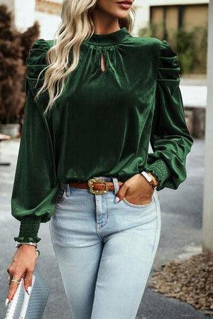 a woman wearing a green top and jeans