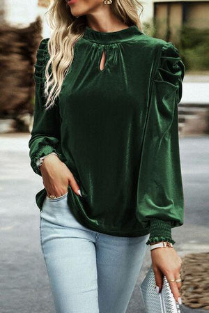 a woman wearing a green blouse and jeans