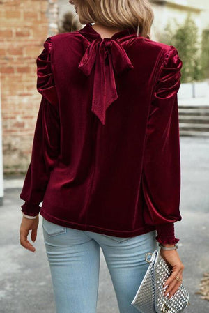 a woman wearing a red blouse and jeans