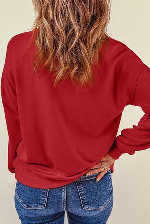 a woman wearing a red top and jeans