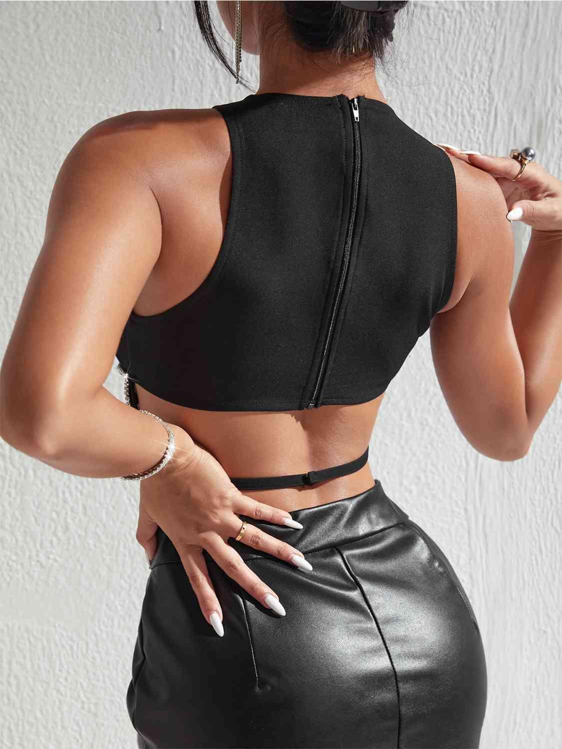 a woman wearing a black crop top and leather skirt