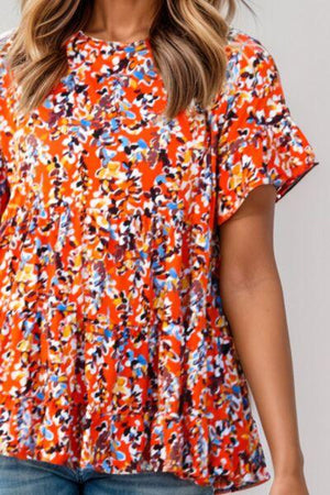 a woman wearing an orange floral top