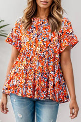 a woman wearing an orange floral top