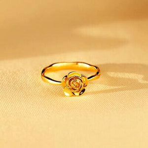 a gold ring with a rose on it