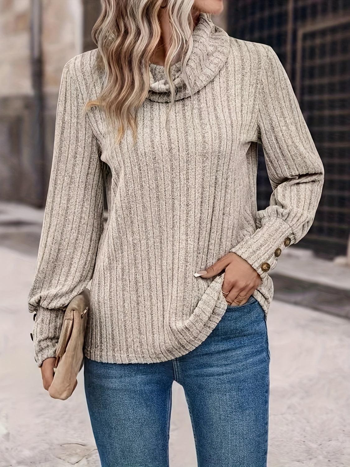 a woman standing on a sidewalk wearing a sweater and jeans