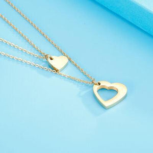 two heart shaped pendants on a blue surface