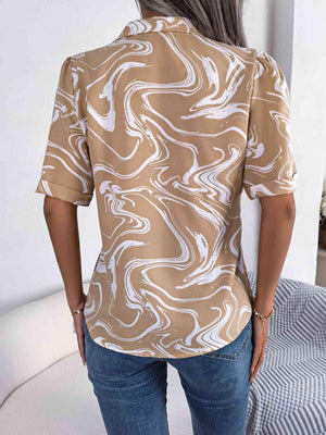 a woman wearing a tan shirt with white swirls on it