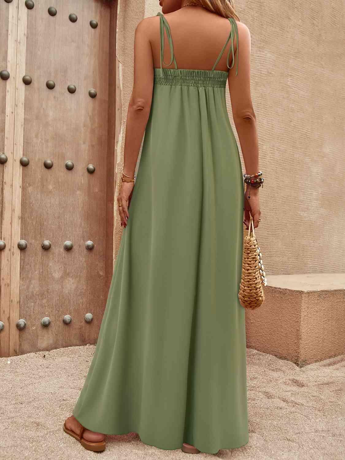 a woman in a long green dress standing in front of a door