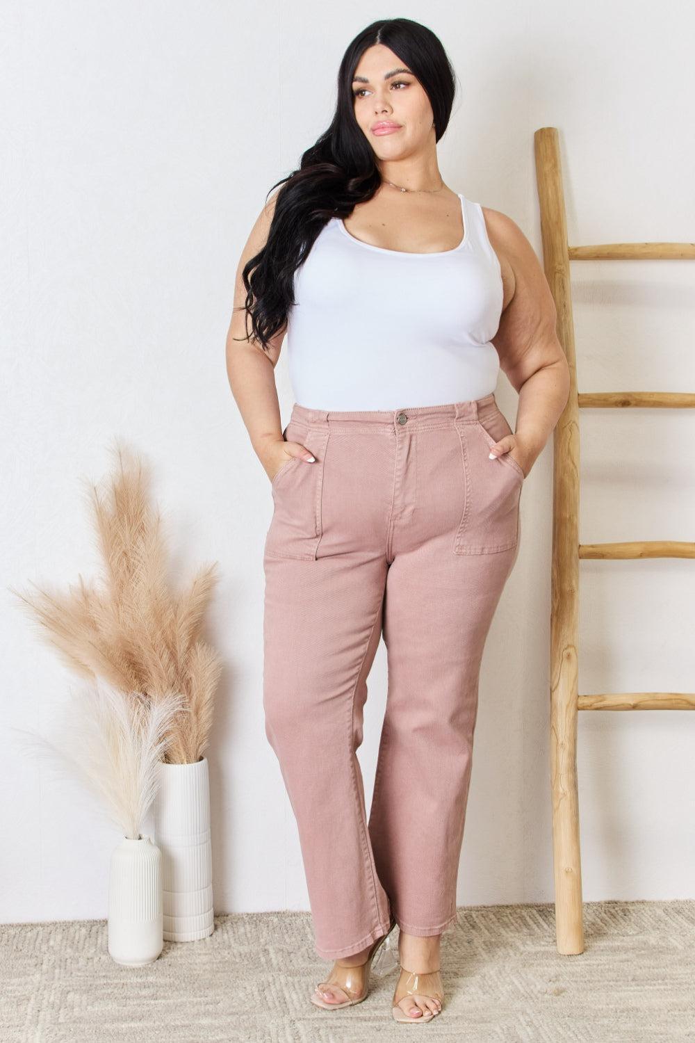 a woman in a white tank top and pink pants