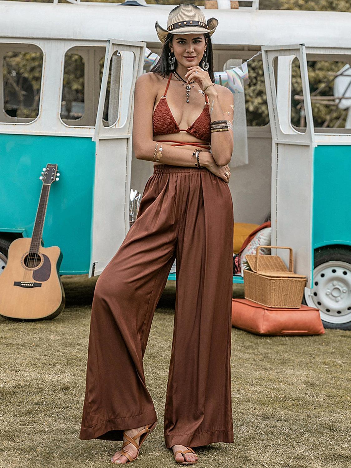 a woman standing in front of a bus wearing a cowboy hat