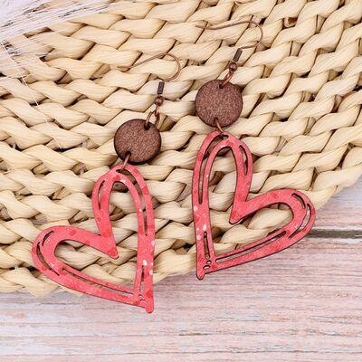 a pair of heart shaped earrings on a basket