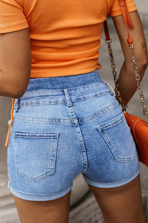 a close up of a person wearing shorts and an orange shirt