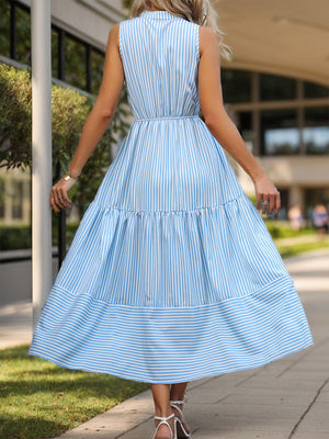 a woman in a blue dress walking down a sidewalk