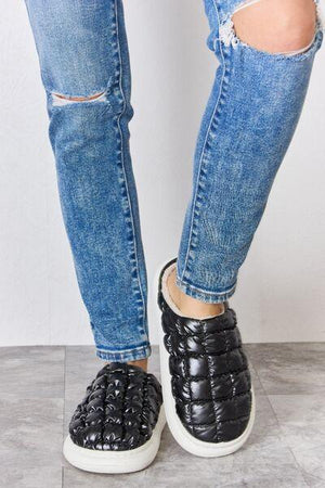 a pair of legs with ripped jeans and black shoes