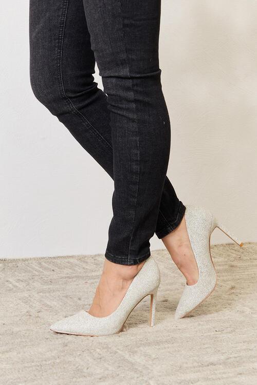 a woman wearing high heels and skinny jeans