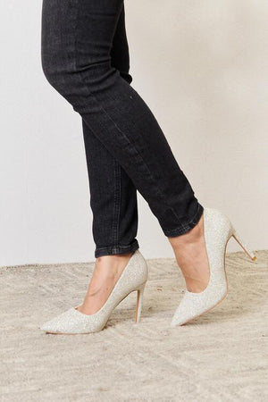 a woman's legs in high heels and jeans