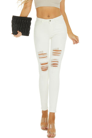 a woman wearing white ripped jeans and a crop top