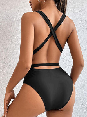 a woman in a black swimsuit with a cross back