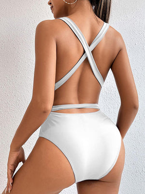 a woman in a white swimsuit with a cross back