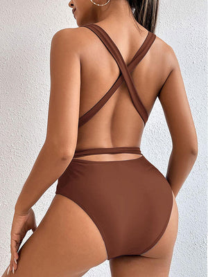 a woman in a brown swimsuit with a cross back